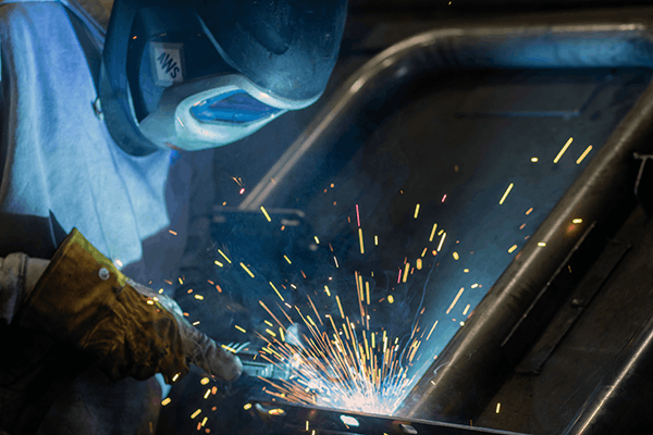 Welder assembling a durable Jamestown Advanced Products picnic table frame